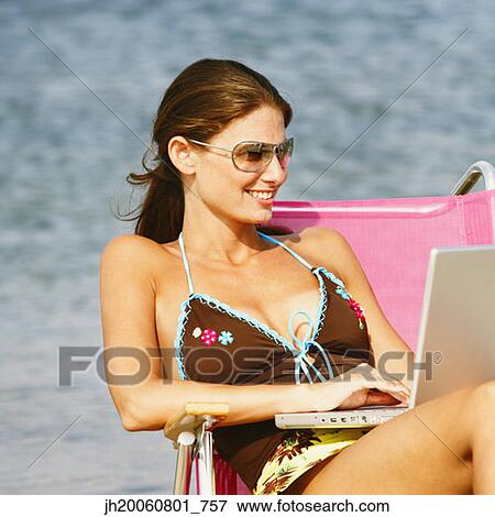 Woman typing on laptop at beach View Large Photo Image Stock Photo - Woman typing on laptop at beach. Fotosearch