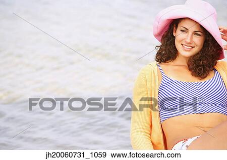 Woman wearing hat at beach View Large Photo Image Stock Photo - Woman wearing hat at beach. Fotosearch