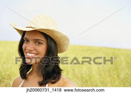 Woman wearing straw hat in field View Large Photo Image Stock Photo - Woman wearing straw hat in field. Fotosearch