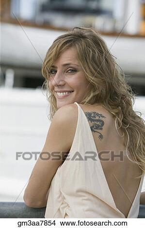 Picture - Woman with tattoo looking over shoulder. Fotosearch