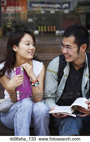 Young Asian couple holding school books View Large Photo Image Stock Image - Young Asian couple holding school books. Fotosearch