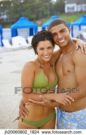 Picture - Young couple hugging at beach. Fotosearch
