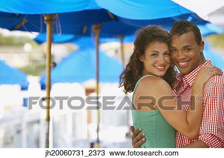 Young couple hugging at beach View Large Photo Image Stock Image - Young couple hugging at beach. Fotosearch