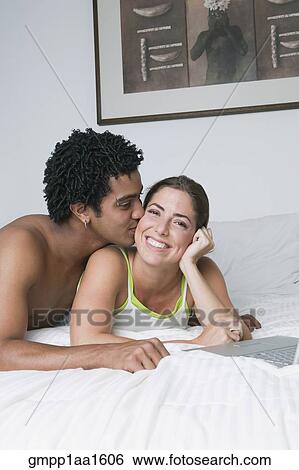 Young couple hugging on bed View Large Photo Image Stock Photograph - Young couple hugging on bed . Fotosearch