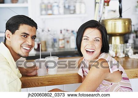 Young couple laughing at bar View Large Photo Image Stock Image - Young couple laughing at bar. Fotosearch