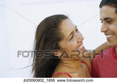 Young couple smiling at each other View Large Photo Image Stock Photograph - Young couple smiling at each other. Fotosearch
