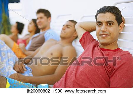Young man in lounge chair View Large Photo Image Stock Image - Young man in lounge chair. Fotosearch