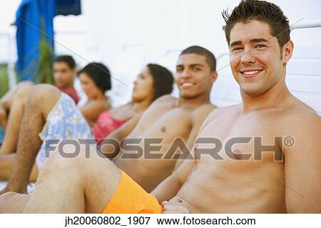 Young man in lounge chair View Large Photo Image Stock Photo - Young man in lounge chair. Fotosearch