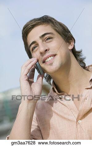 Stock Photo - Young man talking on cell phone. Fotosearch