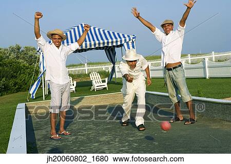 Stock Image - Young men cheering and playing game. Fotosearch