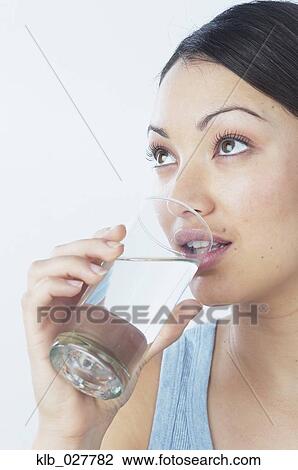 Young woman drinking glass of water View Large Photo Image Stock Image - Young woman drinking glass of water. Fotosearch