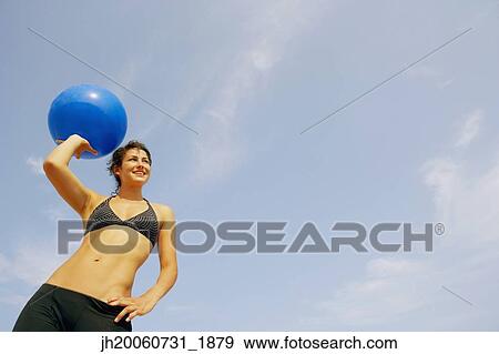 Young woman holding beach ball View Large Photo Image Stock Photo - Young woman holding beach ball. Fotosearch