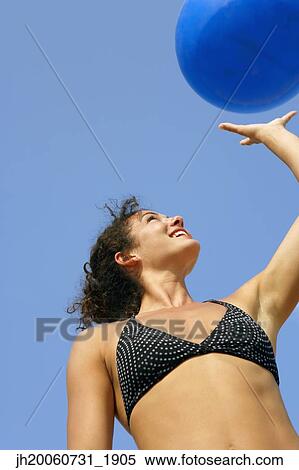 Young woman holding beach ball View Large Photo Image Stock Photography - Young woman holding beach ball. Fotosearch