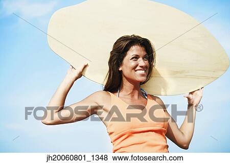 Young woman holding boogie board View Large Photo Image Stock Photo - Young woman holding boogie board. Fotosearch