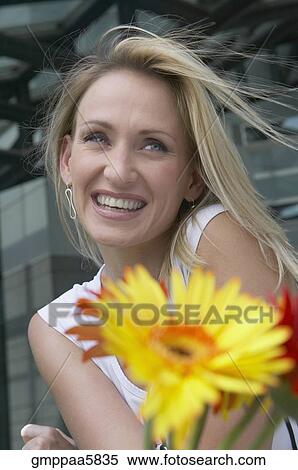Stock Photography - Young woman holding flowers. Fotosearch