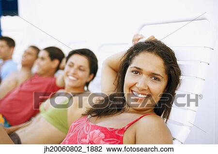 Young woman in lounge chair View Large Photo Image Stock Image - Young woman in lounge chair. Fotosearch
