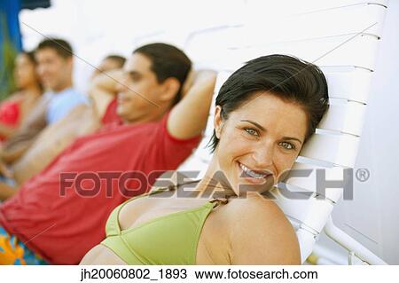 Young woman in lounge chair View Large Photo Image Stock Image - Young woman in lounge chair. Fotosearch