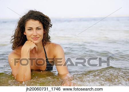 Young woman in water at beach View Large Photo Image Stock Photograph - Young woman in water at beach. Fotosearch
