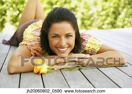 Young woman laying on deck View Large Photo Image Stock Image - Young woman laying on deck. Fotosearch