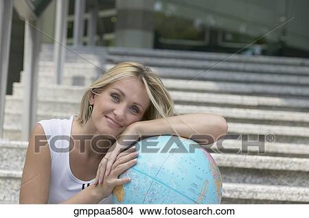 Young woman leaning on globe View Large Photo Image Picture - Young woman leaning on globe. Fotosearch