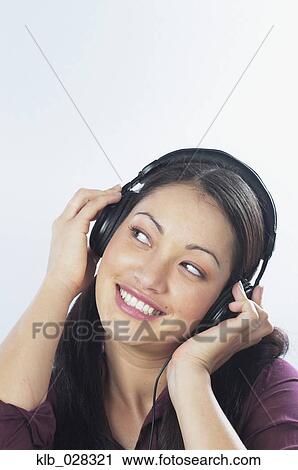 Young woman listening to headphones View Large Photo Image Stock Image - Young woman listening to headphones. Fotosearch