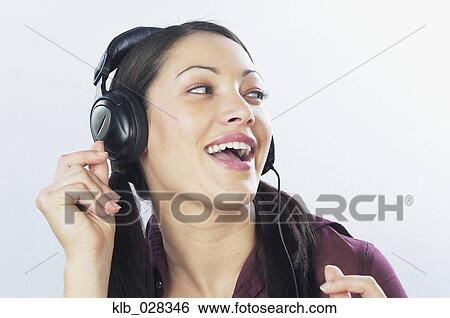 Stock Photograph - Young woman listening to headphones. Fotosearch
