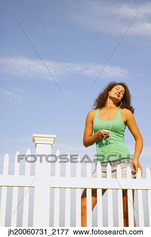 Young woman listening to mp3 player View Large Photo Image Stock Photo - Young woman listening to mp3 player. Fotosearch