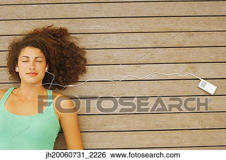 Young woman listening to mp3 player View Large Photo Image Stock Photograph - Young woman listening to mp3 player. Fotosearch