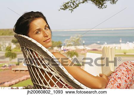 Young woman reading outdoors View Large Photo Image Stock Image - Young woman reading outdoors. Fotosearch