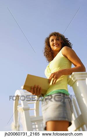 Young woman reading outdoors View Large Photo Image Stock Photography - Young woman reading outdoors. Fotosearch