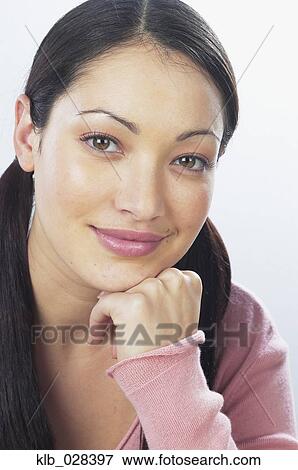 Stock Photo - Young woman resting chin on hand. Fotosearch