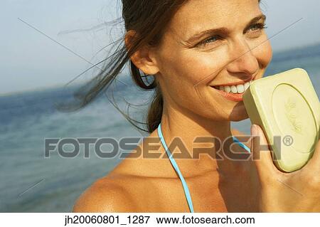 Young woman smelling soap View Large Photo Image Stock Photo - Young woman smelling soap. Fotosearch