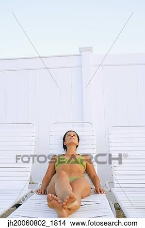 Young woman sunbathing View Large Photo Image Picture - Young woman sunbathing. Fotosearch