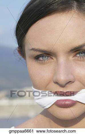 Stock Image - Young woman wearing gag. Fotosearch