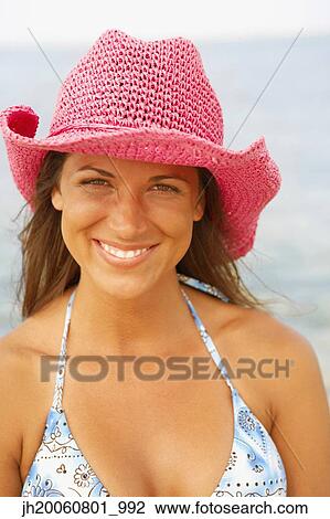 Young woman wearing hat at beach View Large Photo Image Stock Image - Young woman wearing hat at beach. Fotosearch