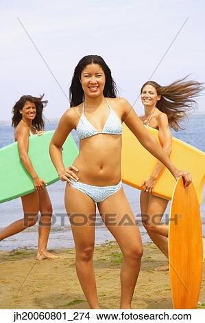 Young women holding boogie boards View Large Photo Image Picture - Young women holding boogie boards. Fotosearch