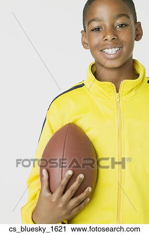 Stock Image - African boy holding football. Fotosearch