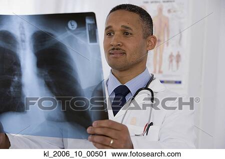 Stock Image - African doctor looking at x-ray. Fotosearch