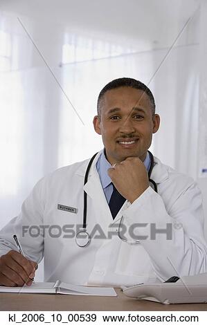 Stock Photo - African doctor writing in notebook. Fotosearch