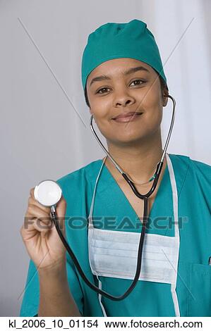 Picture - African female doctor holding up stethoscope. Fotosearch