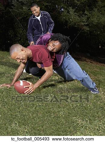 Stock Image - African friends playing football. Fotosearch