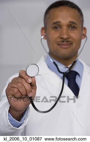 African male doctor holding up stethoscope View Large Photo Image Stock Photo - African male doctor holding up stethoscope. Fotosearch