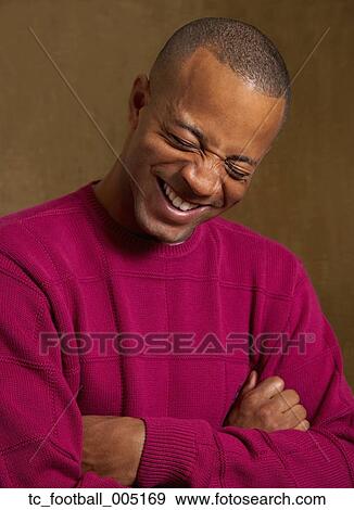 Stock Photo - African man laughing with arms crossed. Fotosearch