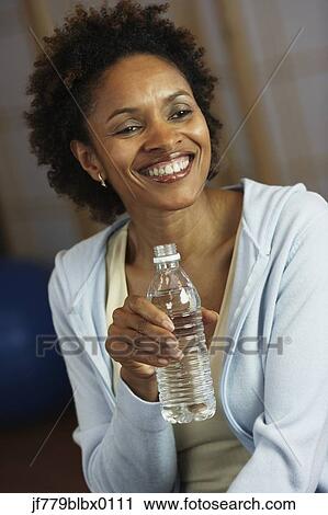African woman drinking from water bottle View Large Photo Image Stock Image - African woman drinking from water bottle. Fotosearch