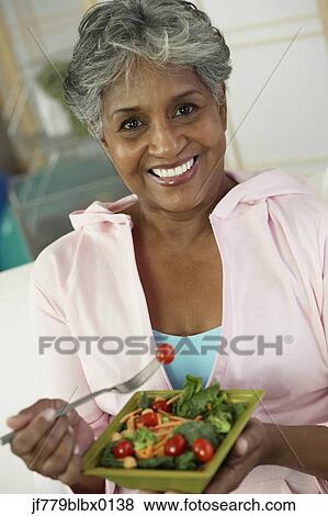 African woman eating salad View Large Photo Image Stock Photo - African woman eating salad. Fotosearch