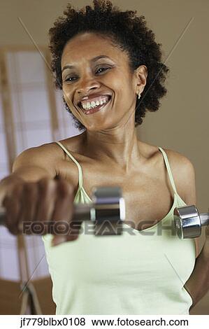 Stock Photo - African woman exercising with weights. Fotosearch