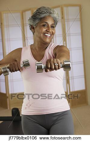 Stock Photograph - African woman exercising with weights. Fotosearch