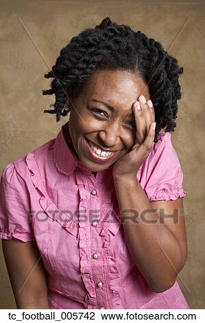 African woman laughing with hand on face View Large Photo Image Stock Image - African woman laughing with hand on face. Fotosearch