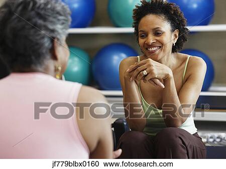 Stock Image - African women talking at health club. Fotosearch