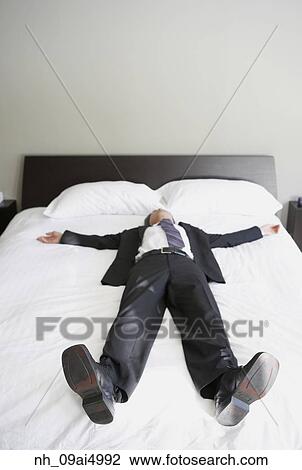 Asian businessman laying on bed View Large Photo Image Stock Image - Asian businessman laying on bed. Fotosearch